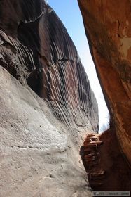 The trail going through a large fissure in the bedrock in Kane Gulch.