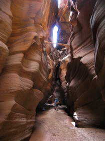 Chuck hiking under a large debris dam in Buckskin Gulch.