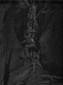 Chuck climbing over a flood debris dam in Buckskin Gulch.