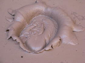 Long after the rock hit bottom, the splash remains on the surface of a mud pit in Paria Canyon.